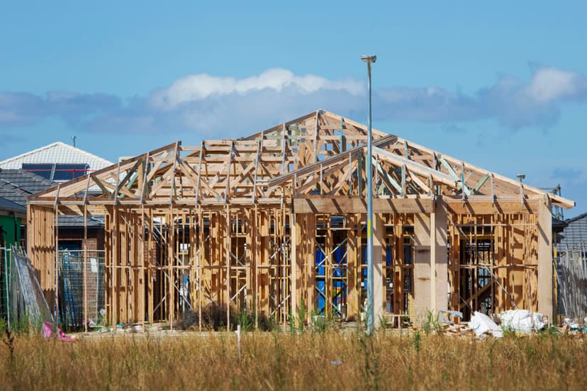 Wooden frame structure of residential house under construction with blue sky